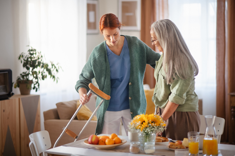 Nurse helping senior woman with walking after leg injury